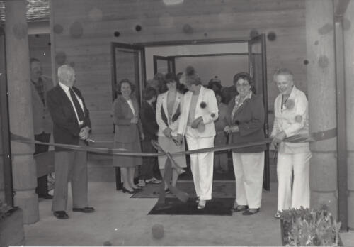 Black and white photo of a group of people at the library opening ribbon cutting