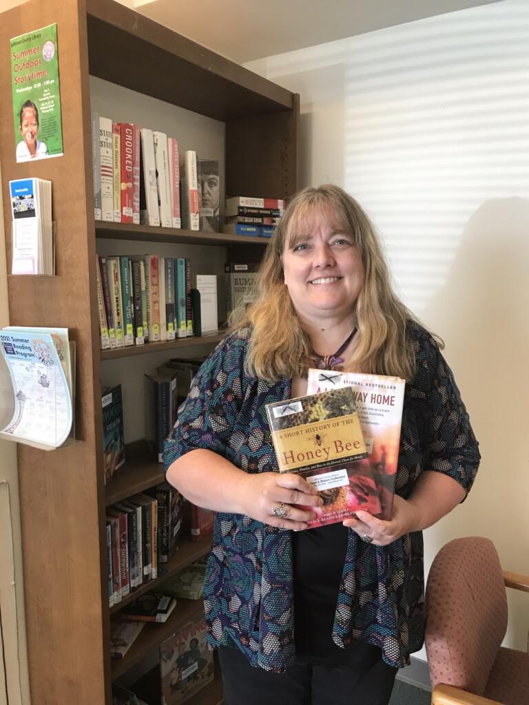 Woman smiling and holding up books