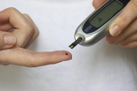 Hands using a blood glucose test meter