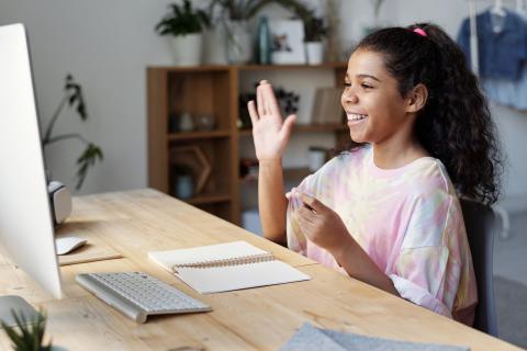 Young girl smiling in front of a laptop