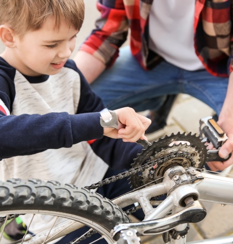 boy fixing bicycle with help from dad