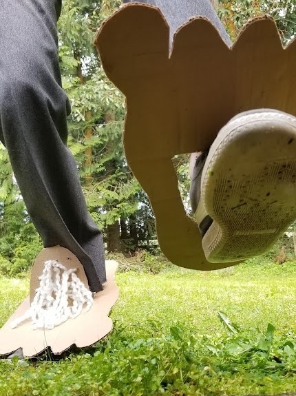 Man walking in giant cardboard feet