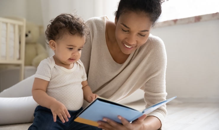 Five Practices to Support Early Learning stock image showing a young mother with a baby and an open book in front of them