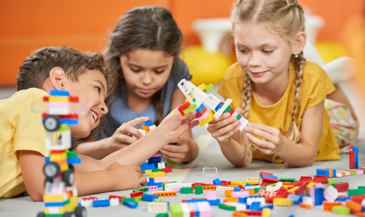 Three children playing with building blocks