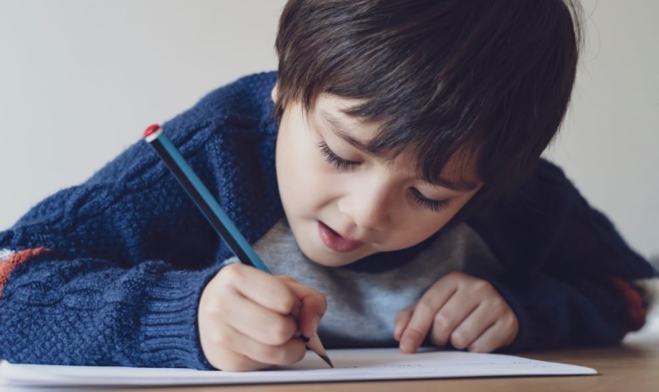 Homework Help image showing boy working on homework sheet