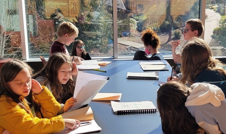 Quilcene School District showing students sitting at a large table with papers in front of them