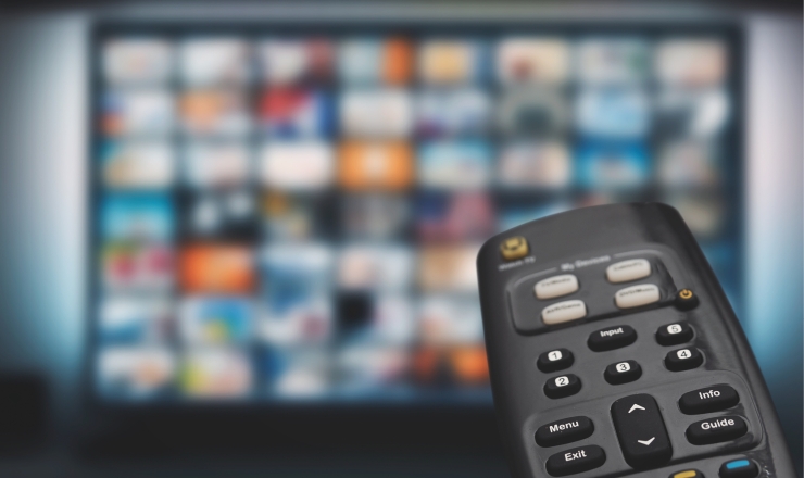 Streaming Movies linked image showing someone holding a remote pointed to a tv