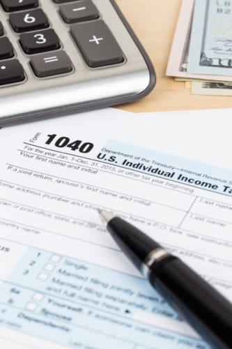 Tax forms, a calculator, and a pen for filing your income tax.